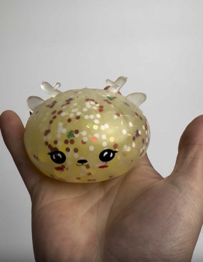 Glittery reindeer dumpling squishy toy held in a hand
