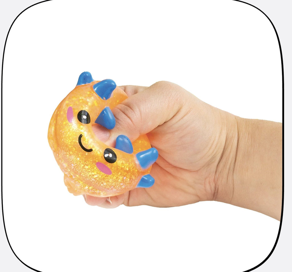 A hand squeezing an orange glitter axolotl squishy